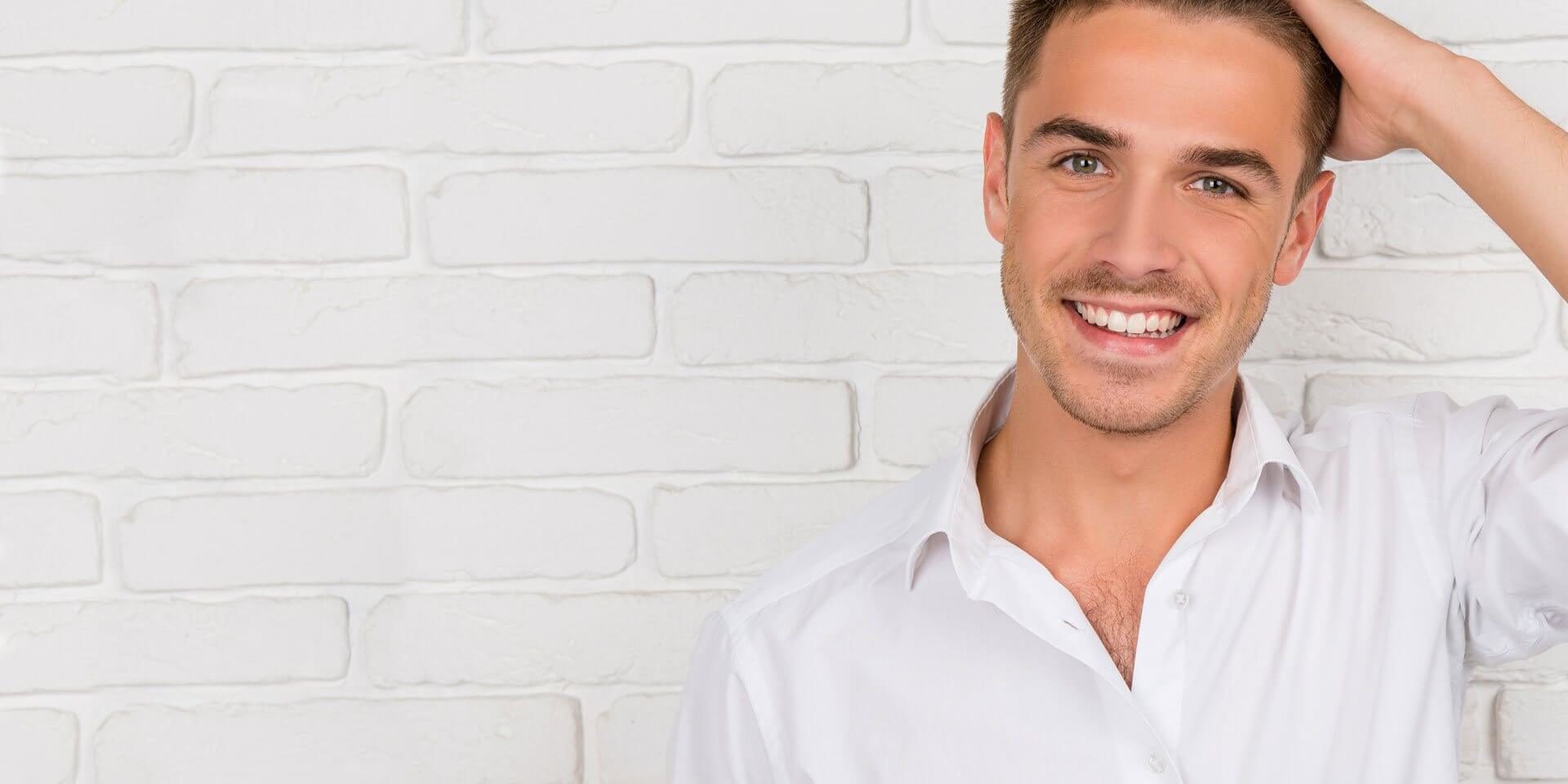 injerto-capilar Hombre sonriendo y tocándose el pelo